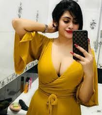 A YELLOW DRESS WEARING SEXY GIRL 25 YEARS OLD TAKING SELFIE SERSELF INFRONT OF THE MIRROR